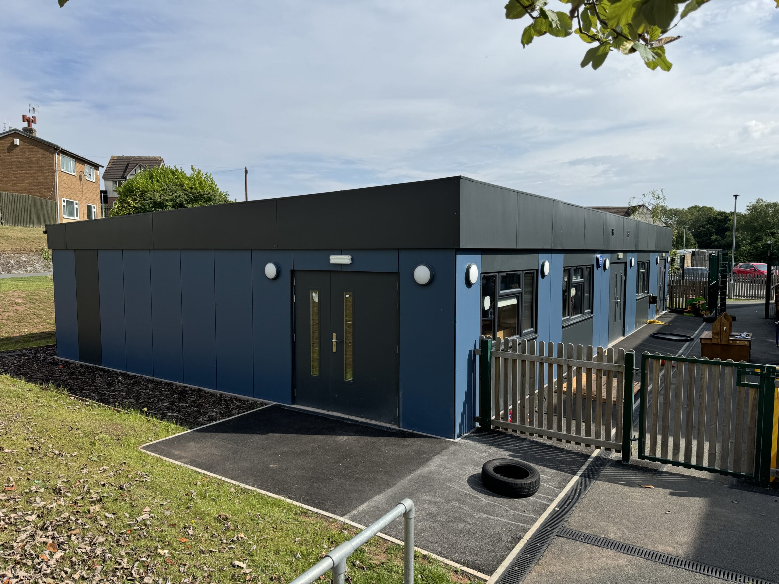 image shows a blue modular school building