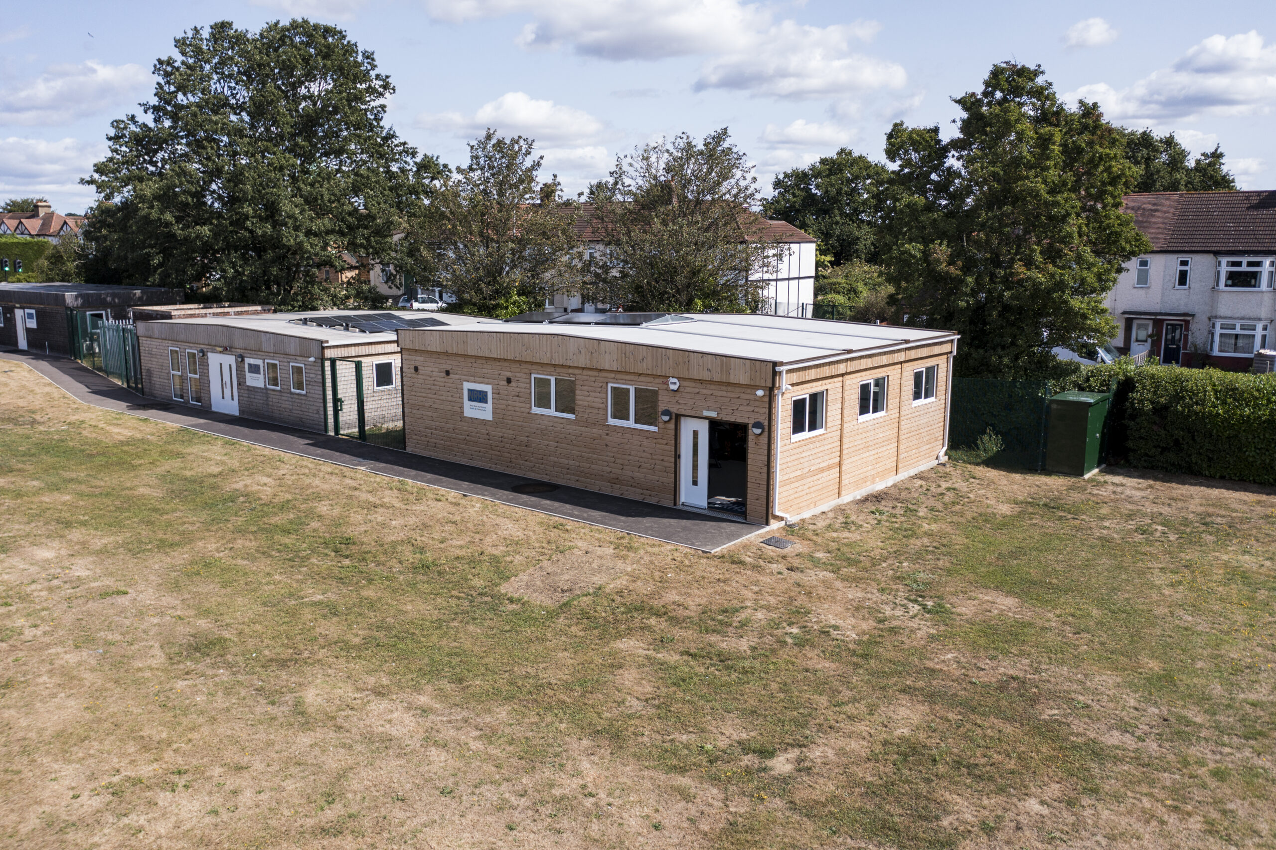 A modular building from an aerial view with grass and trees